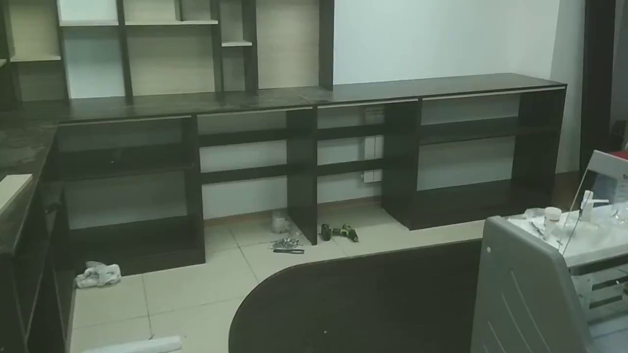 Собранные тумбы вдоль стены и стеллаж над ними