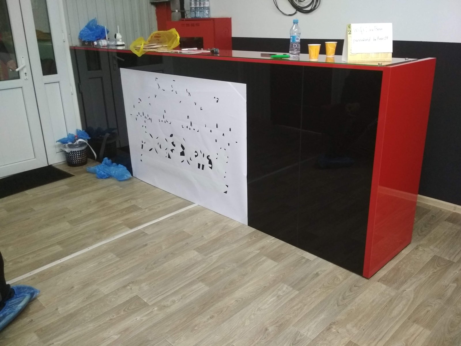 Ресепшен с перфорированной белой панелью на чёрном фасаде